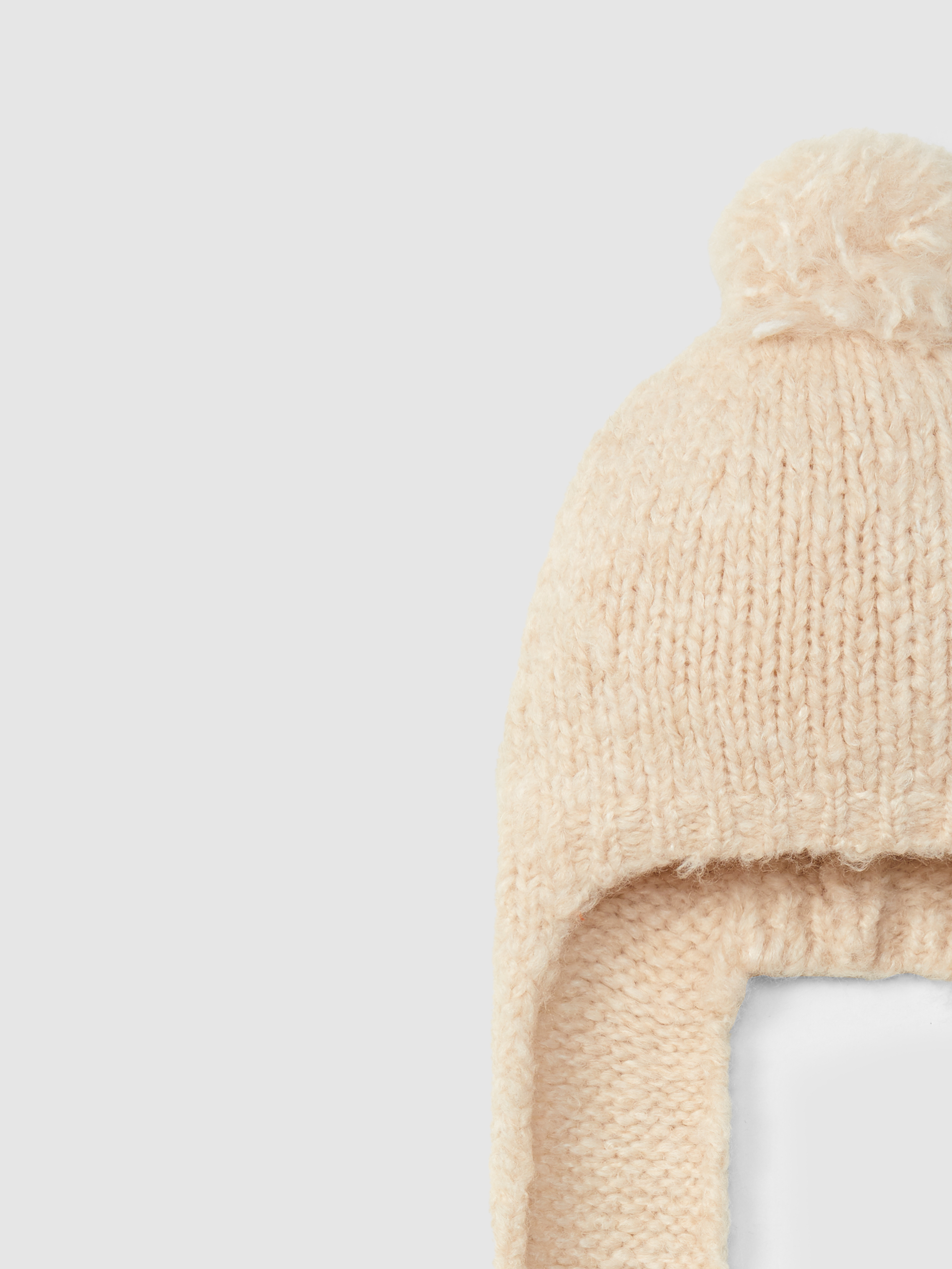Gorro tricotado con pompón y cintas